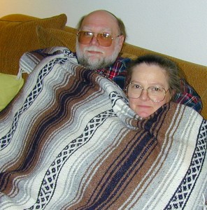 Ken Steinhoff and Lila Steinhoff, huddled under a blanket on son Matthew's sofa.